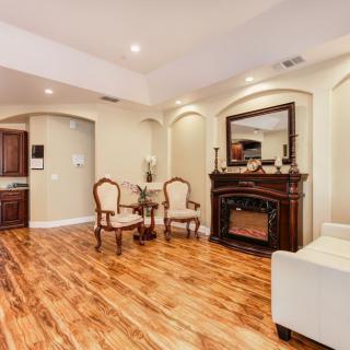 A cozy living room with hardwood floors, traditional furniture, and a fireplace.
