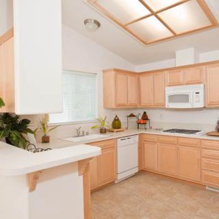 A modern kitchen with wooden cabinets and bright lighting.