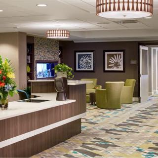 Modern hotel lobby with a reception desk and seating area.