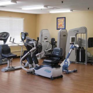 A gym room with various exercise equipment including stationary bikes and weight machines.