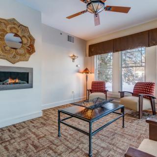 A cozy living room featuring a modern fireplace, stylish furniture, and large windows allowing natural light to fill the space.