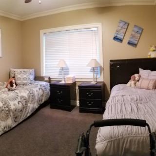 A cozy bedroom with twin beds, nightstands, and soft lighting.