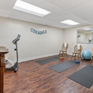 A well-equipped exercise room with yoga mats, a stationary bike, and fitness accessories.