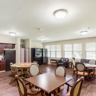 A spacious dining area with multiple tables and chairs, featuring large windows and ample lighting.
