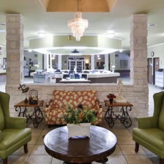A cozy lobby with elegant seating and a central chandelier.