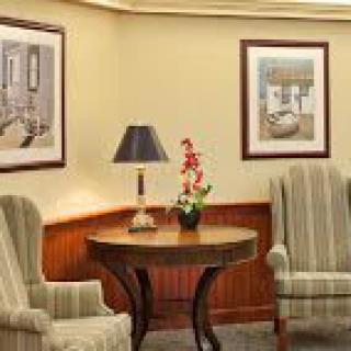 A cozy living room setup with two chairs, a round table, and wall art.