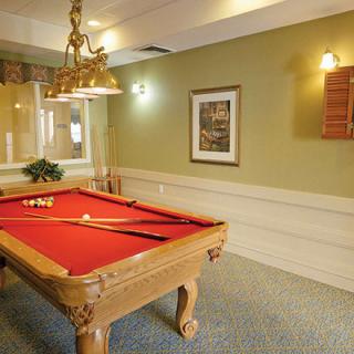 A cozy game room featuring a billiard table with red felt and traditional decor.