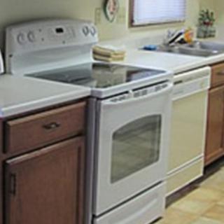 A kitchen featuring a stove, oven, and dishwasher set against wooden cabinetry.
