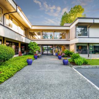 A modern building with large glass windows and well-maintained landscaping.