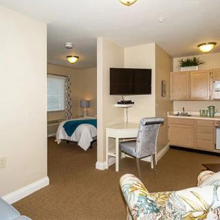 A cozy studio apartment featuring a bedroom, kitchenette, and living area.