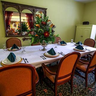 A well-decorated dining table set for a formal dinner with floral centerpiece and elegant place settings.