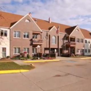 A residential apartment building with multiple units and a parking area in the front.