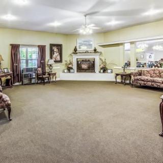 A spacious living room with elegant furniture and a central fireplace.