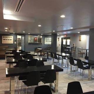 A modern cafeteria with neatly arranged tables and chairs.