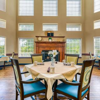 Spacious dining area with large windows and a central fireplace.