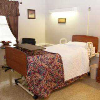 A neatly arranged hospital room with a bed and furnishings.