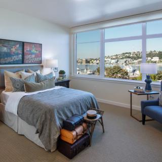 A modern bedroom with a large window overlooking the city.