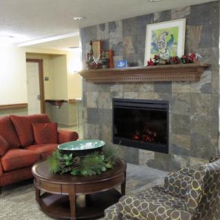 A cozy living room featuring a stone fireplace, comfortable seating, and decorative elements.