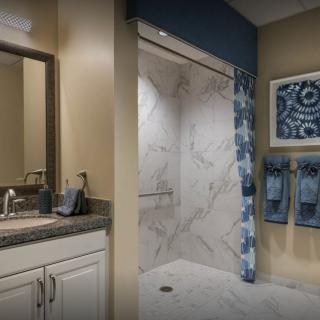 A modern bathroom with a marble shower and stylish decor.