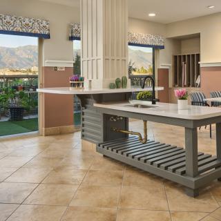 A modern kitchen interior with large windows and a central countertop.