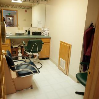 A small hair salon with styling stations and chairs.