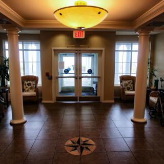 A cozy lobby entrance with columns, seating areas, and natural light.