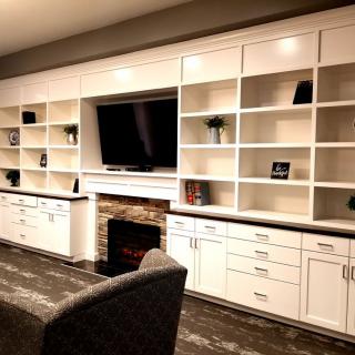 A modern living room with built-in shelves, a TV, and a fireplace.