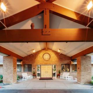 A well-lit entrance of a building with a wooden porch.