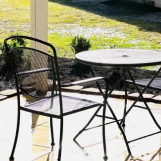 A sunny outdoor patio with a metal table and chair set.