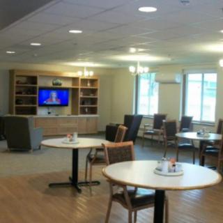 A modern lounge with seating areas, tables, and a television.