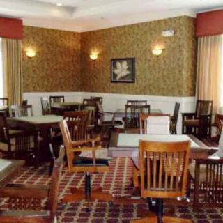 An empty restaurant dining area with wooden tables and chairs.