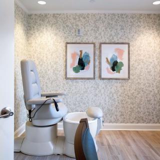 A cozy salon space featuring a pedicure chair and modern artwork on the walls.