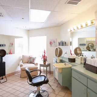 A cozy and well-lit hair salon interior with styling chairs and mirrors.