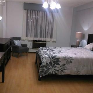 A cozy bedroom with a double bed, nightstand lamps, and a window with curtains.
