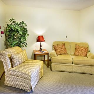 A cozy living room with a sofa, armchair, and decorative elements.