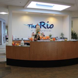 Reception area at The Rio featuring a welcoming desk and decorative elements.