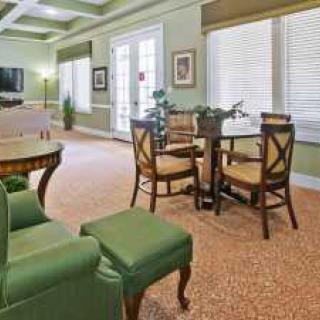 A cozy living room with green furnishings and ample natural light.