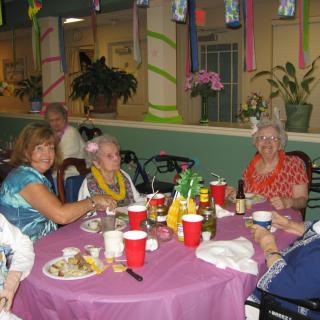 A group of people enjoying a festive gathering at a decorated table with food and drinks.
