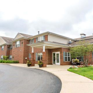 A modern residential building with a brick facade and landscaped entrance.