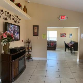 A cozy living space featuring a television, decorative elements, and a view into a dining area.