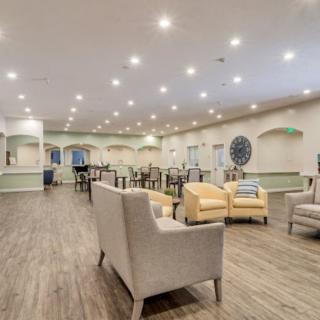 Spacious and well-lit modern lounge area with comfortable seating and tables.