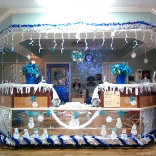 A beautifully decorated indoor space with a winter theme, featuring blue and white decorations.