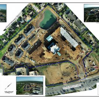 Aerial view of a construction site surrounded by residential buildings and roads.