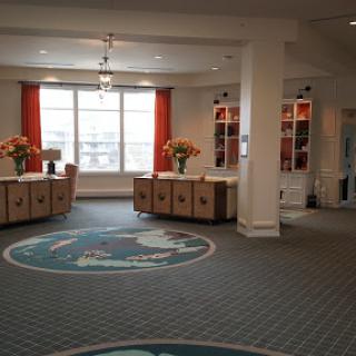 A welcoming lobby area featuring reception desks, floral decorations, and natural light.