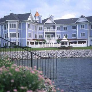 A large, elegant building with a waterfront view and manicured landscape.