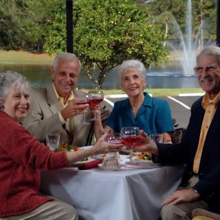 A joyful gathering of friends enjoying drinks together outdoors.