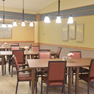 An empty restaurant dining area with neatly arranged tables and chairs.