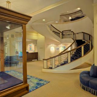 A spacious and elegantly designed lobby featuring a winding staircase and contemporary furnishings.