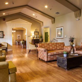 A modern living room with wooden floors and comfortable seating arrangements.