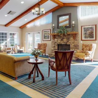 A spacious and inviting lobby area featuring comfortable seating, a fireplace, and natural lighting.
